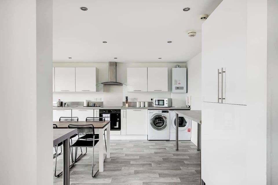 Kitchen: Sleek white cabinets and modern appliances for delightful meals and easy entertaining! 