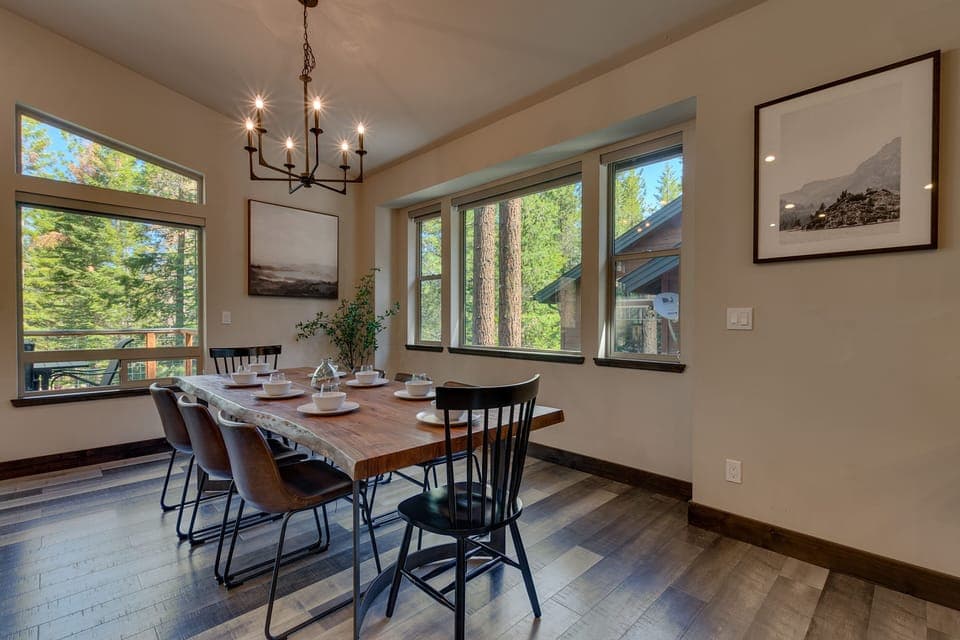 - Dining room with rustic wood table  
- Seating for group gatherings cabin  
- Surrounded by large bright windows