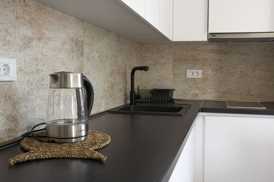 Full size kitchen with fridge, electric kettle, kitchenware, etc