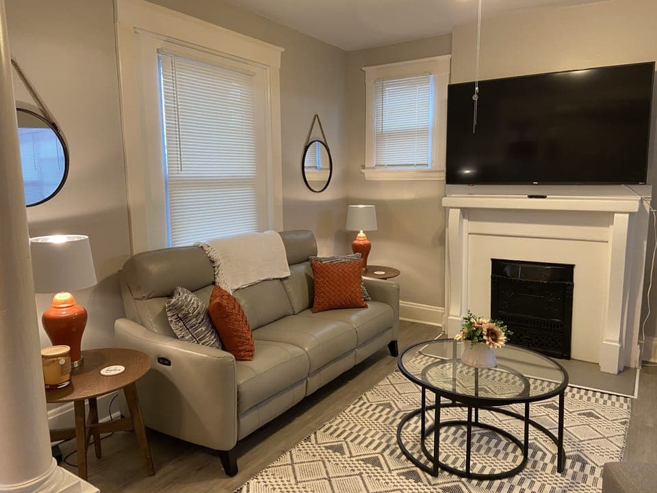 Living space with leather couch, powered recliners, and 65” RokuTV