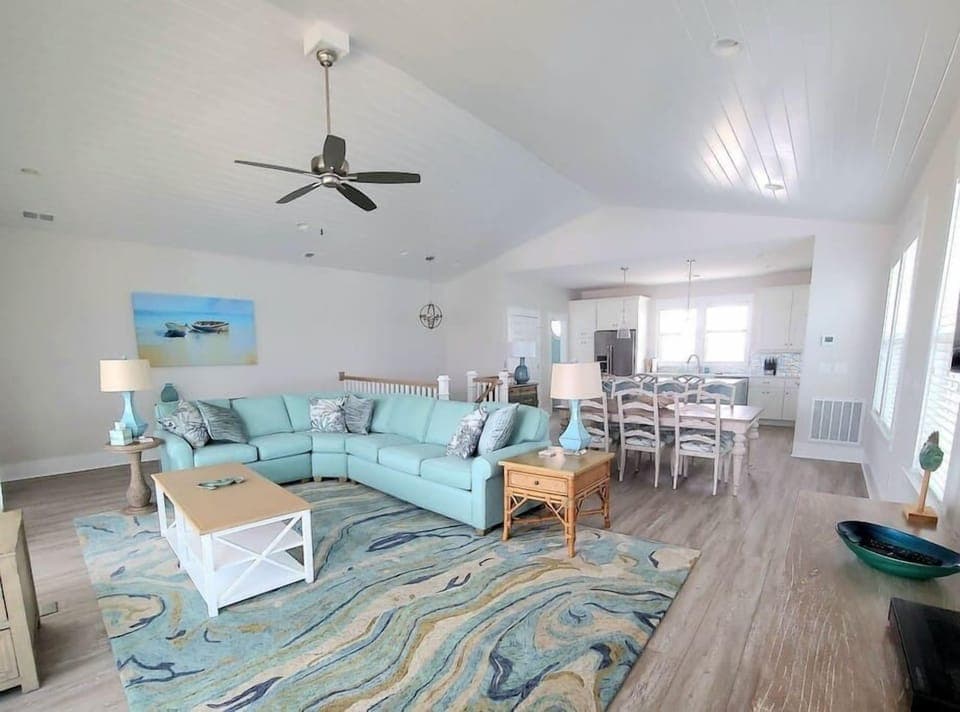 Bright and sunny living room with open kitchen and dining room concept.  Vaulted ceilings. 