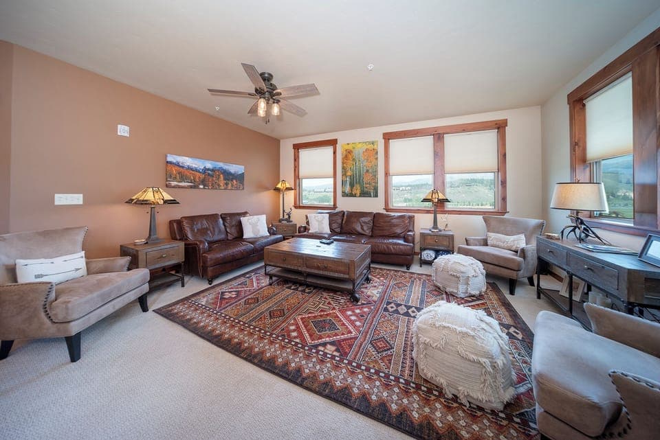 Sink into rich leather sofas surrounded by warm wood tones and mountain views from your spacious living room retreat.