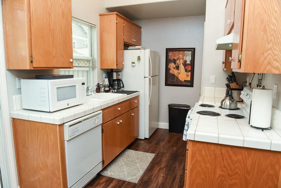 Full kitchen with electric stove, microwave, coffee maker and kettle