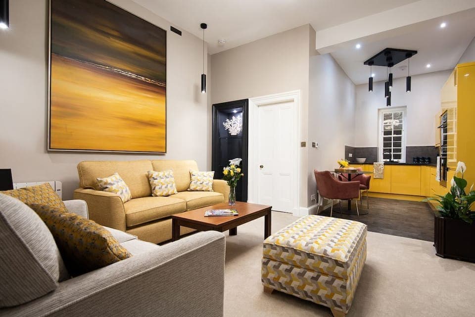 The Scott Apartment - open-plan living space has a spacious seating area and sleek yellow kitchen