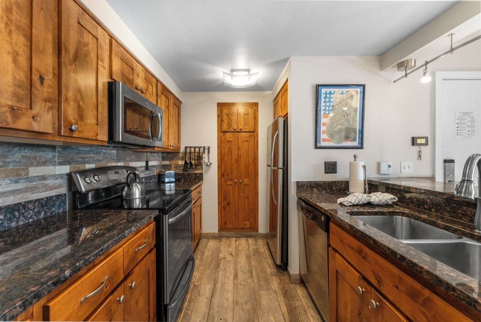 Updated full size kitchen with granite countertops, stainless steel appliances, and breakfast bar for additional seating