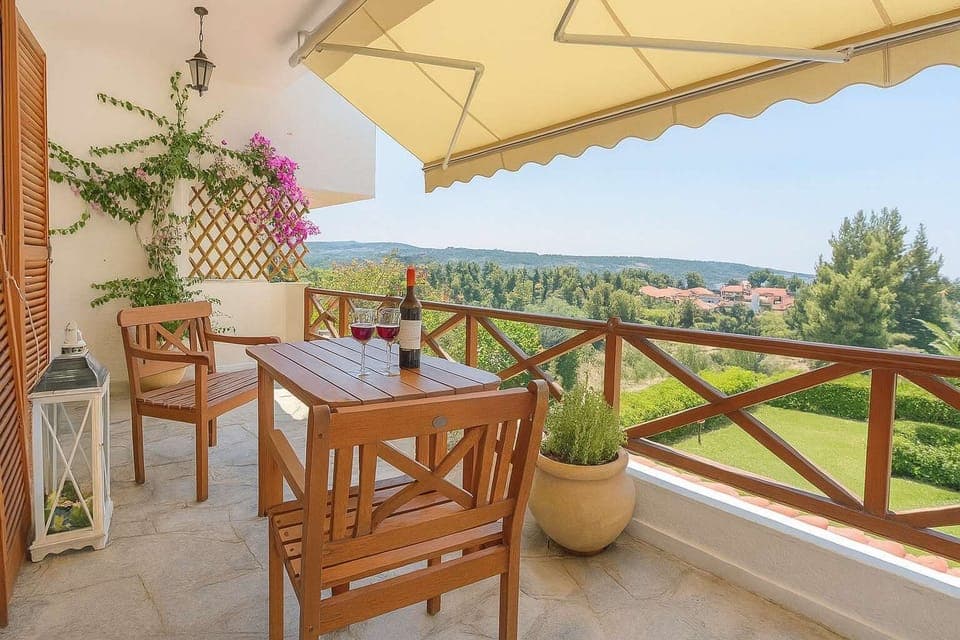 Relax and unwind on the villa’s charming shaded veranda, complete with a comfortable dining table, surrounded by lush greenery and offering the perfect setting for enjoying a leisurely breakfast or an evening drink outdoors.

