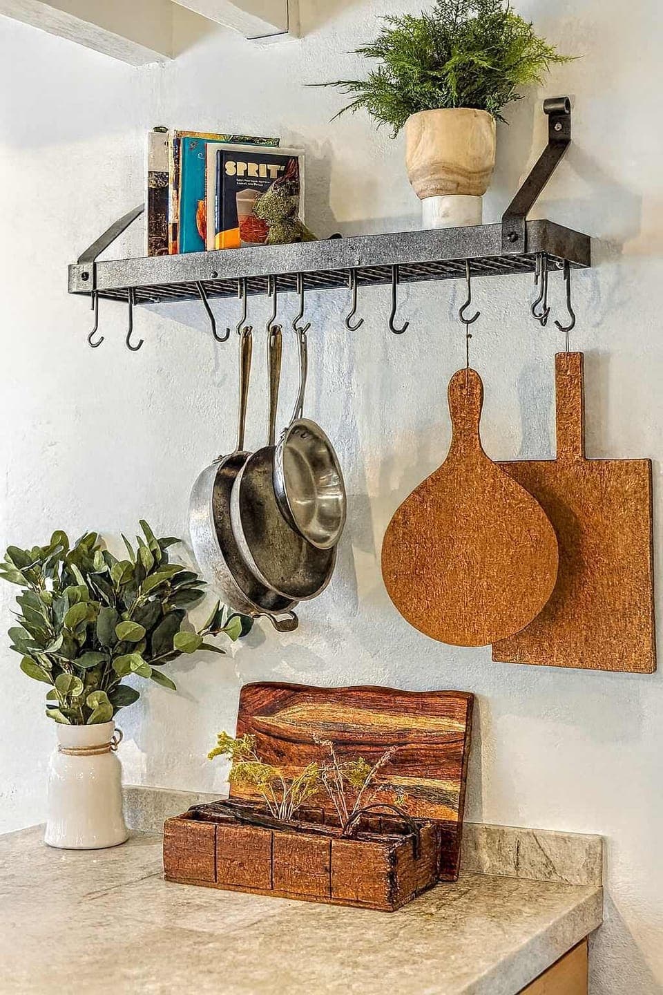 Charming kitchen touches include rustic pots, wooden boards, and greenery that brighten the space. Thoughtful décor and handy storage create a warm, inviting spot to prep meals.
