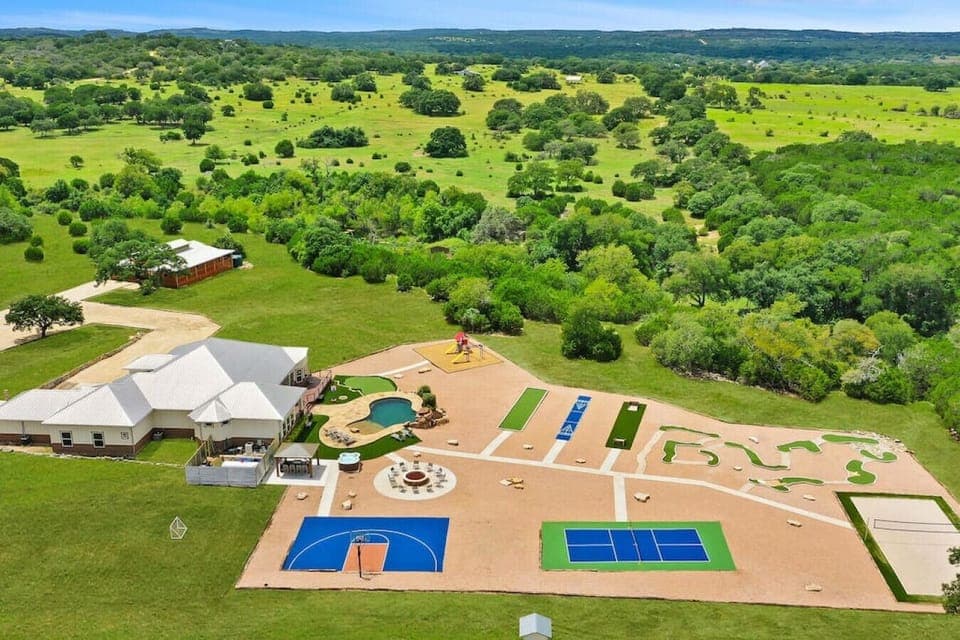 [Resort Property] Aerial view of the property showing basketball court, volleyball, pickleball, mini golf, heated pool, fire pit, and more!