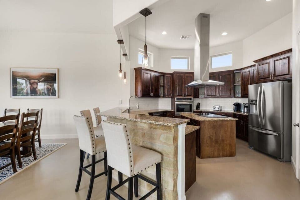 [Main Kitchen] Spacious kitchen with breakfast bar seating for 4 and open to the dining room