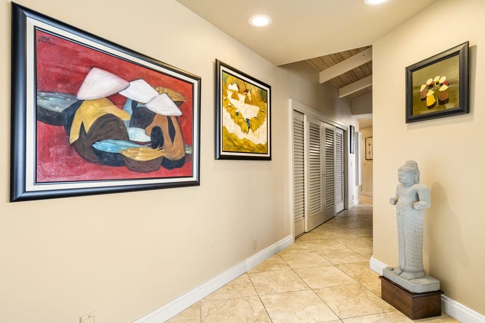 Hallway leading to the two guest bedrooms—lined with art and natural light.