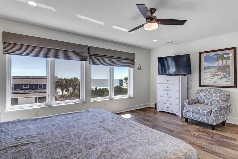 - Start your mornings with breathtaking ocean views from this king bedroom retreat
- Flat screen TV, printed accent chair, and artwork create a relaxing ambiance
- Four large windows frame beach and palm views for a peaceful escape