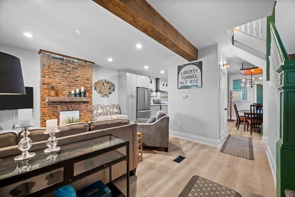 A view of the front door looking into the dining, kitchen and living room area. The first floor powder room is located in the center area where the door is pictured.