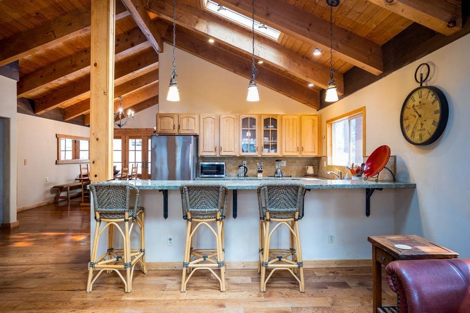 The spacious living room and kitchen are seamlessly connected, offering a bar seating area that's perfect for mixing drinks or casual meals