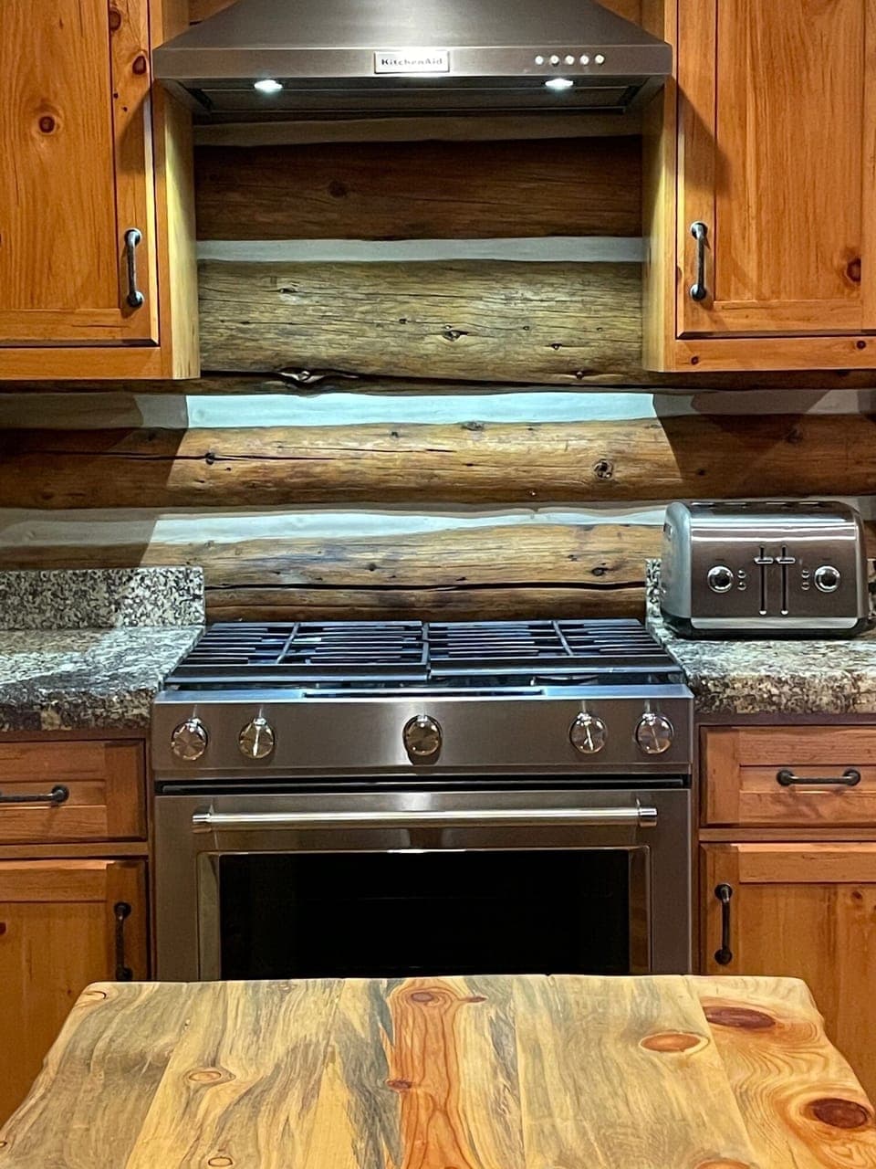 Kitchen Aid gas cooking range and hood.