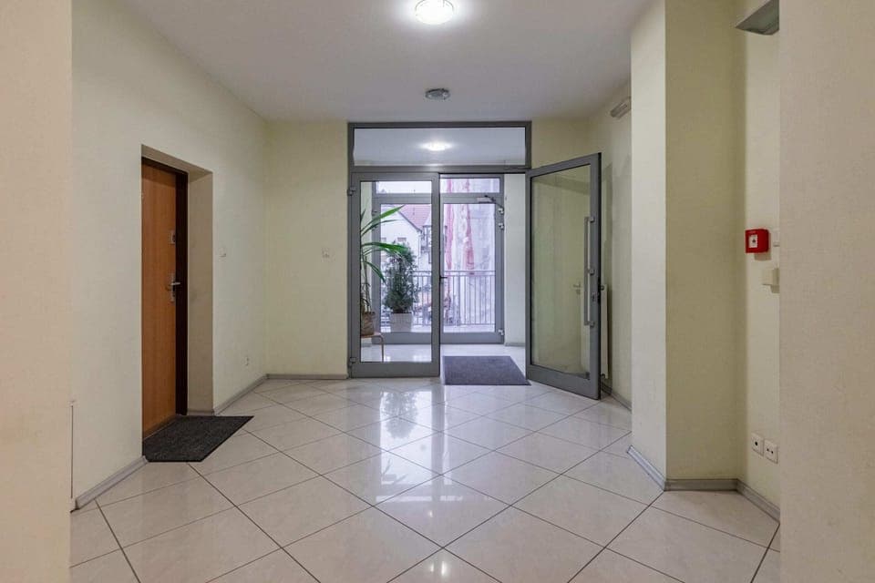 The apartment building's hallway with tiled flooring and simple decor, creating a welcoming entrance for residents and guests.