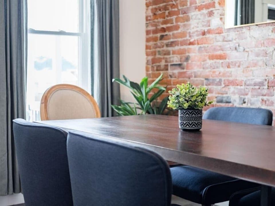 Stylish dining area featuring wooden table and exposed brick for a modern look.