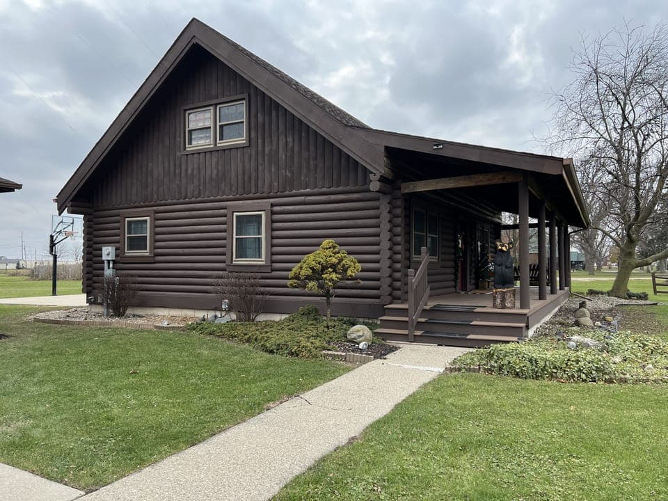 View when walking up to the log cabin. Side view of the home.