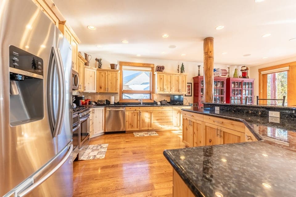 Spacious updated kitchen with modern stainless steel appliances, granite countertops and small flat screen TV.