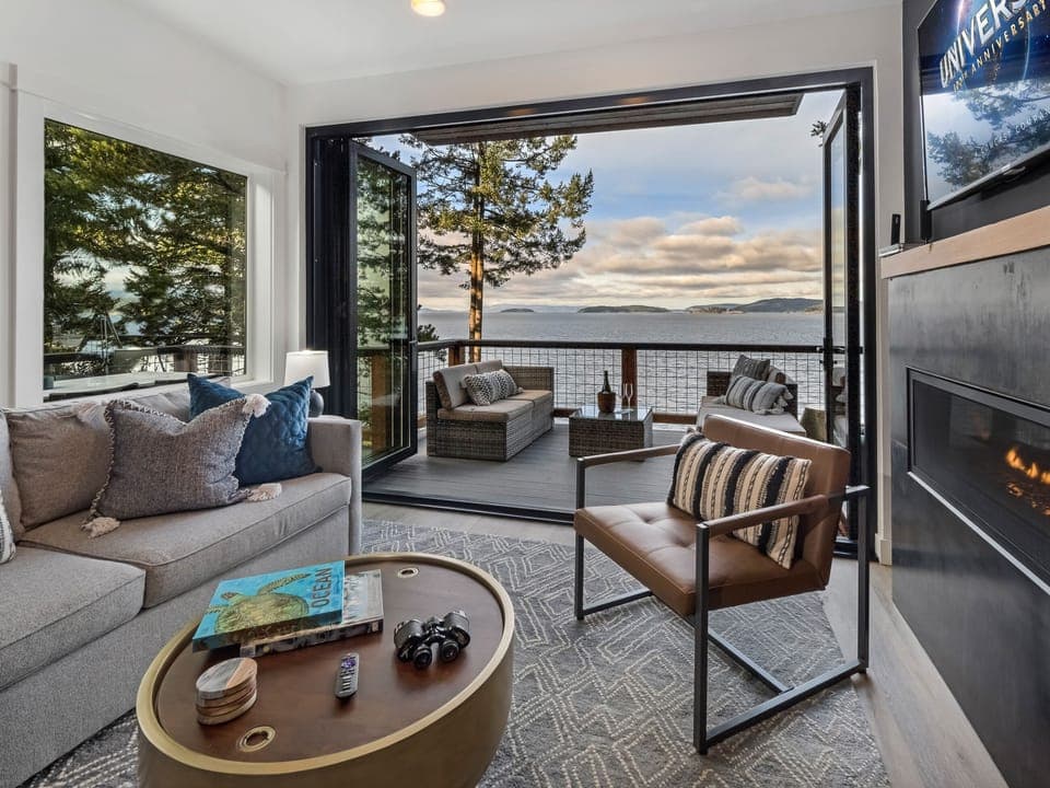 Cover photo - There is a cozy fireplace in the living room with an accordion glass wall opening the entire house to the stunning Salish Sea 

**Not suitable for children under 16 due to high bank waterfront.**