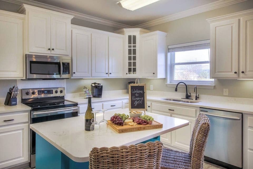 The newly renovated kitchen has white quartz countertops, white subway tile and stainless steel appliances.
