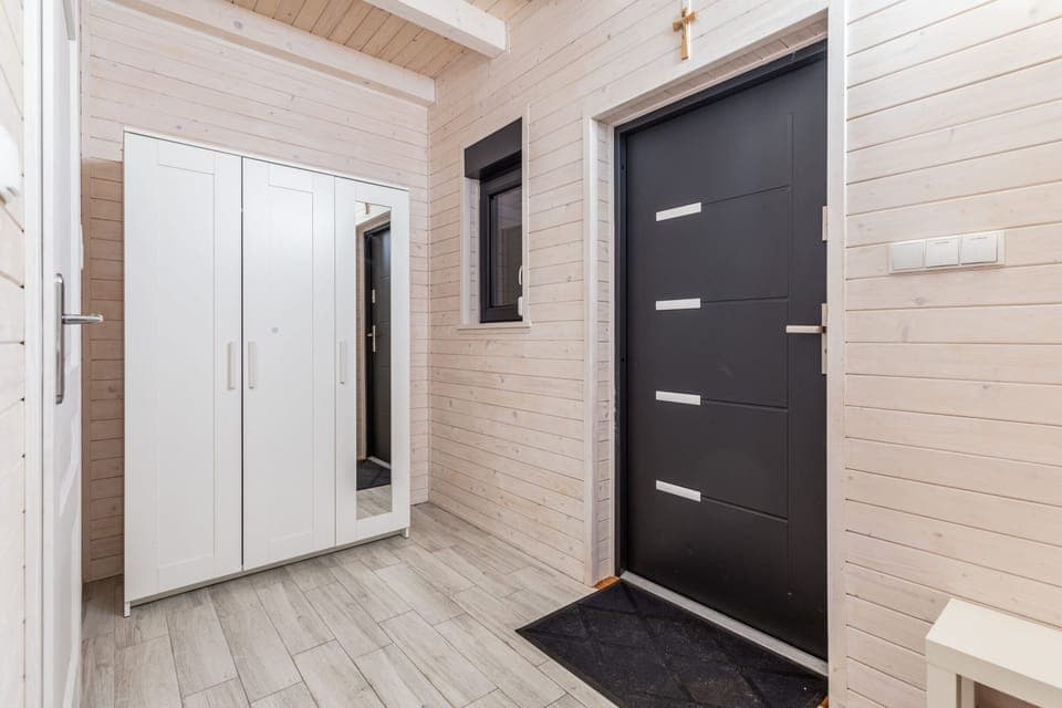 Boarded corridor with a large white wardrobe.