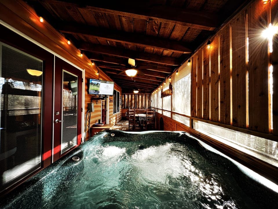 Watch TV from the hot tub located steps from the King size bed