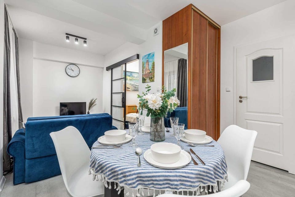 A small dining space with a round table, modern chairs, and a minimalist design.
