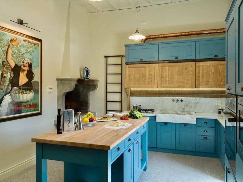 The spacious kitchen includes a wood-burning fireplace, a butcher block centre island, and  J. A. Henckels chef’s knives and silverware.