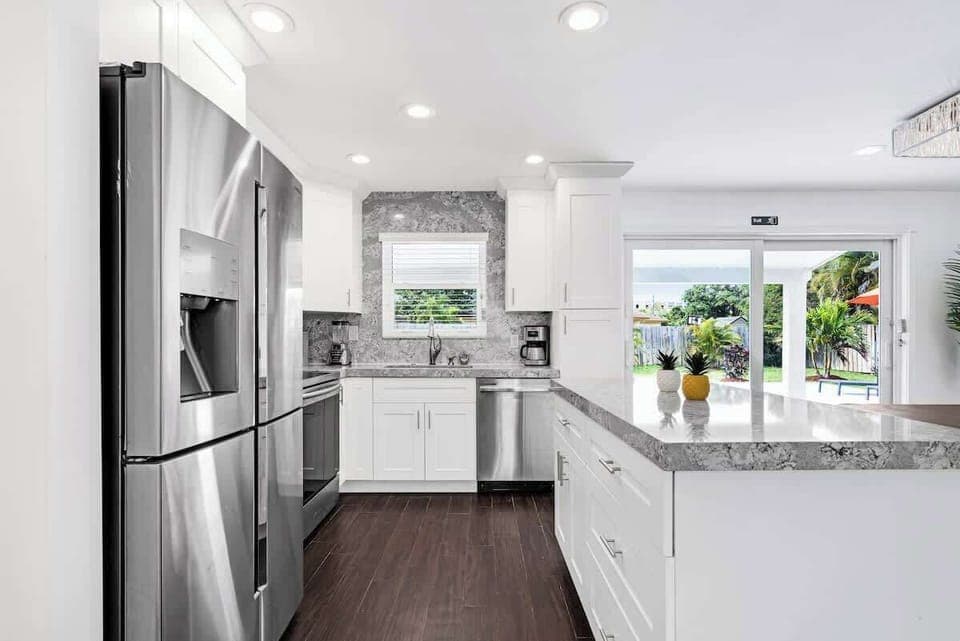 🍽️ Cook, connect, and unwind in this sleek vacation rental kitchen! Featuring stainless steel appliances, granite counters, and easy access to outdoor dining—perfect for family meals or remote work retreats.