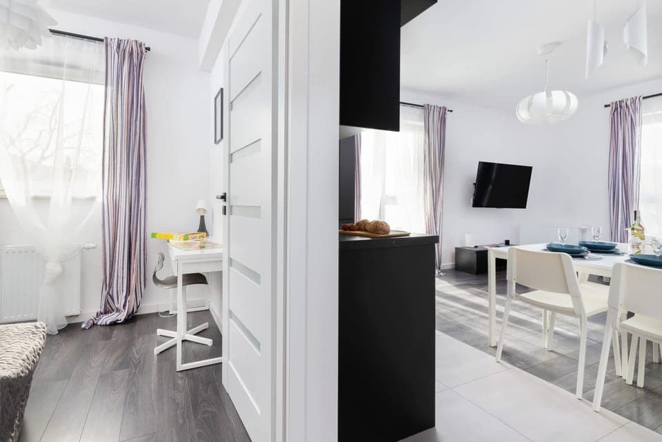 A cozy living room area with a table, decorative items, and bright windows.