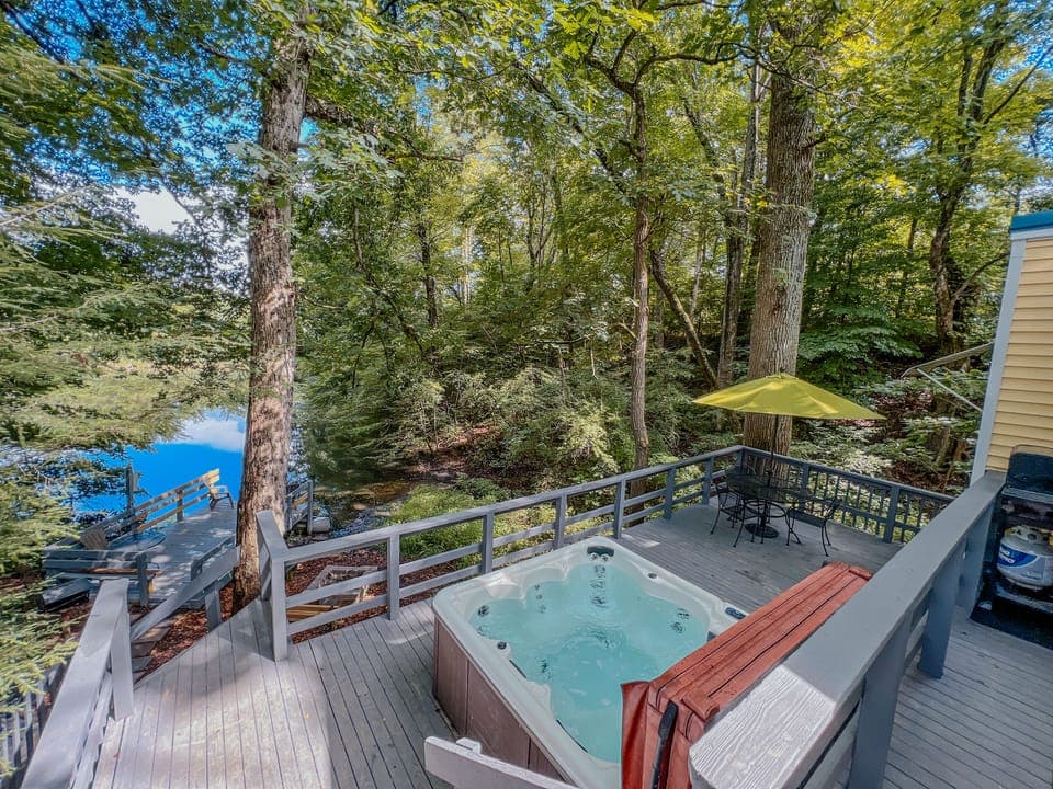 View from the back deck overlooking the hot tub, patio set, and fire pit. 