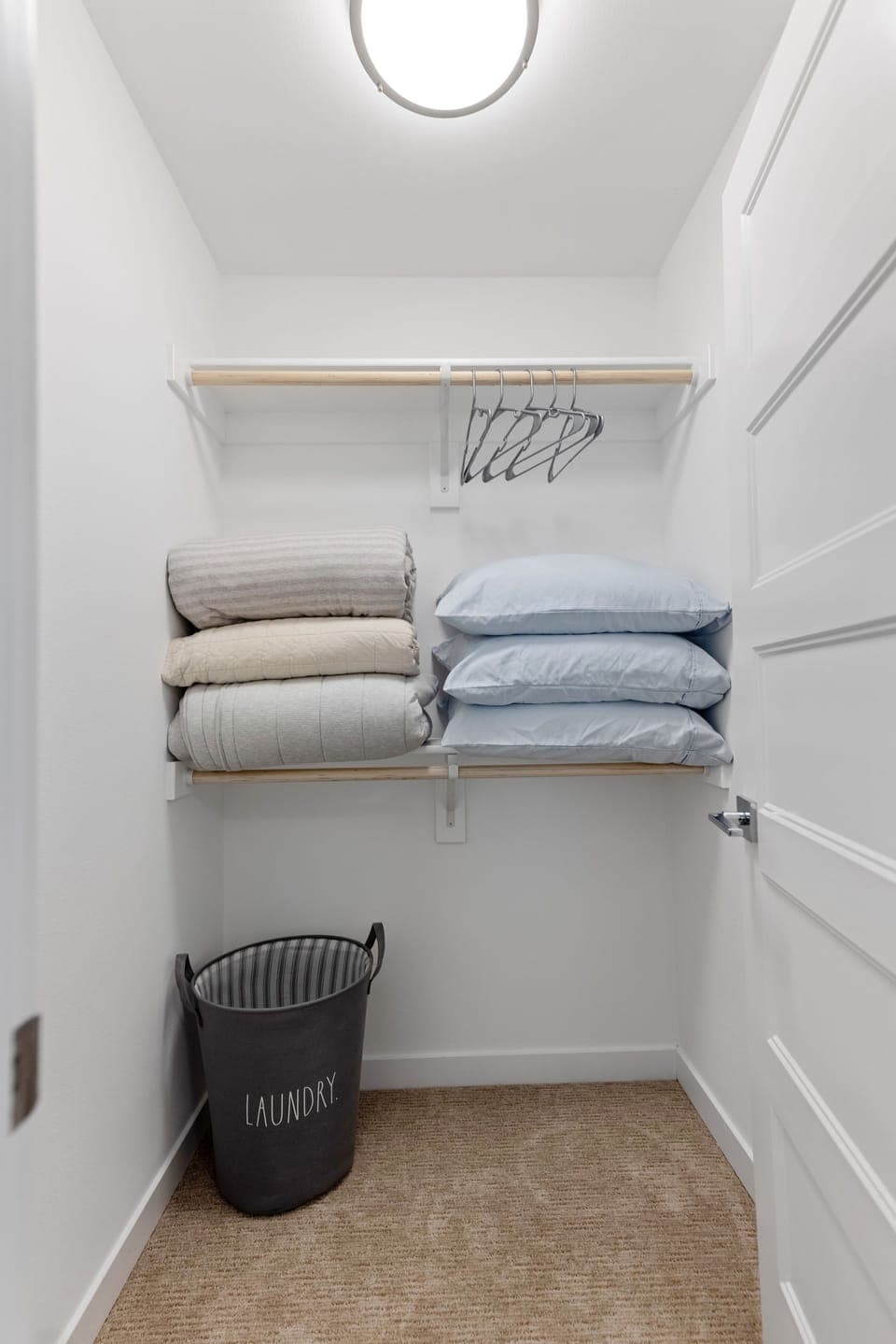 Bedroom closets include hangers, laundry basket and extra pillows. 