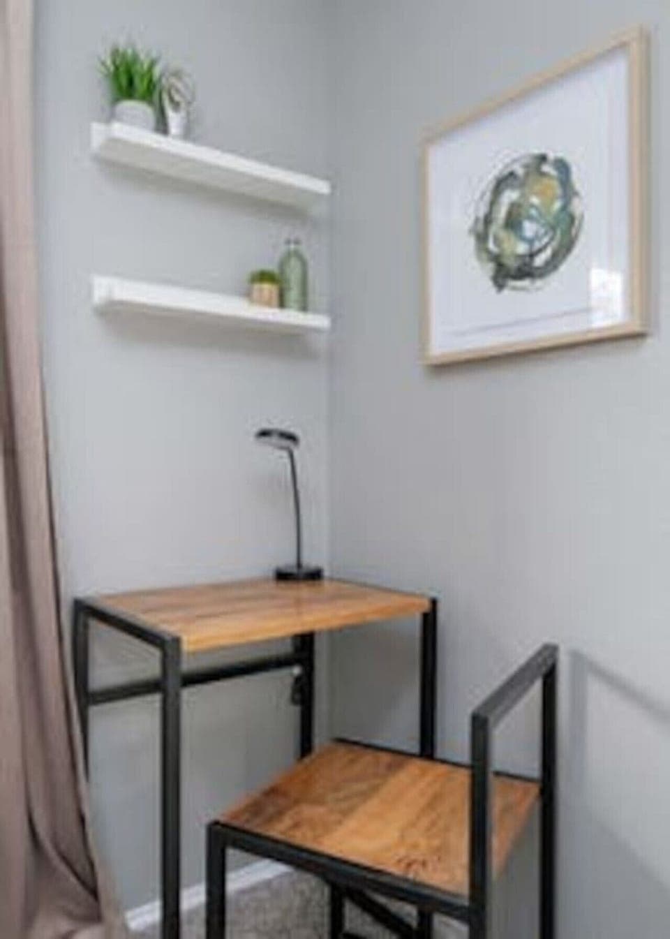 A dedicated work nook at Boni and Blithe featuring a wood desk, open shelving, and natural light—ideal for focused business travel stays.