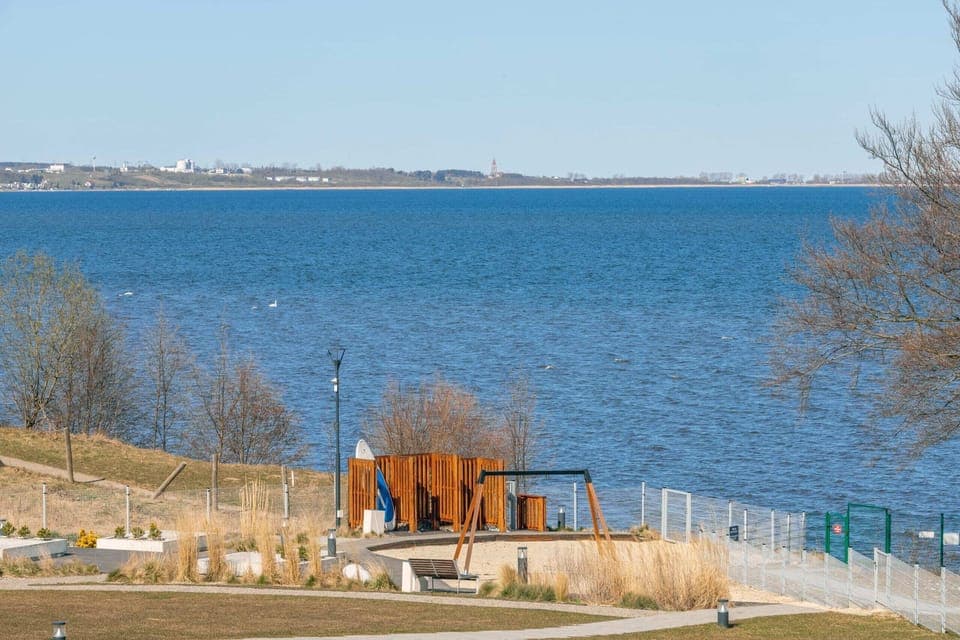 Scenic waterfront view with calm waters, trees, and a beautiful natural landscape.
