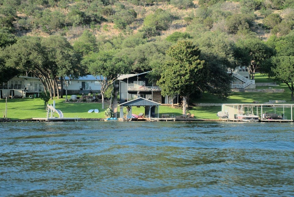 House and boat dock in center, view from across cove.