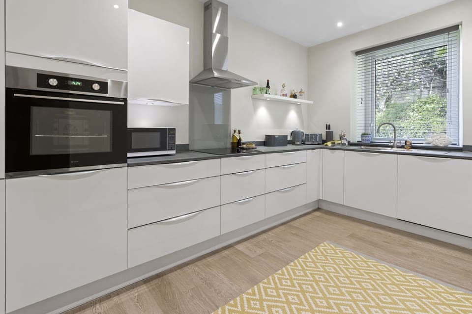 Modern kitchen with all you need for your stay including a kettle, bread bin and cooking utensils.