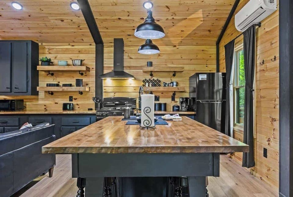 Modern kitchen with black island and wood countertop for rustic charm