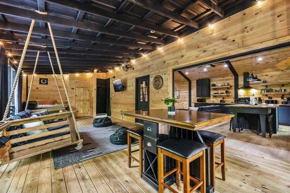 Fully enclosed porch featuring gas grill, dining table, swing, and outdoor spa