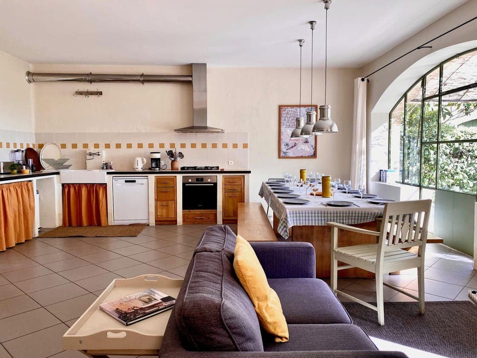 A large, bright cooking and dining area. The 2,20m long table can sit up to 14