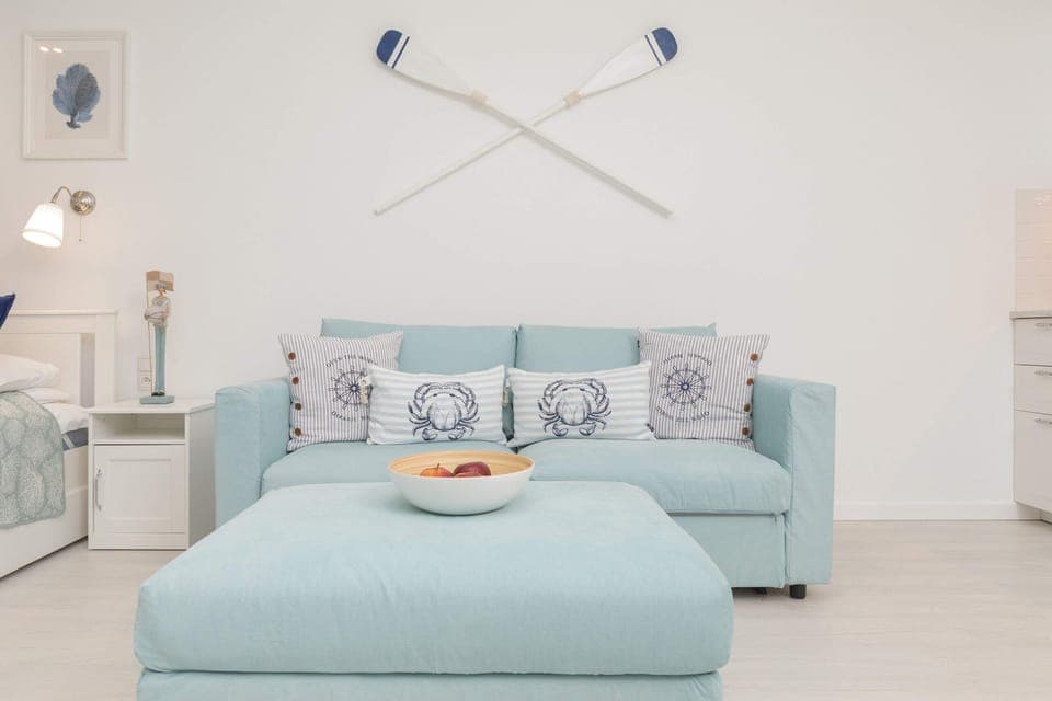 Modern and bright studio with a sofa bed and TV.