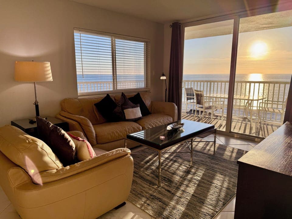 Unwind in your oceanfront living room where golden sunlight streams through windows, creating perfect ambiance for morning coffee or sunset cocktails.