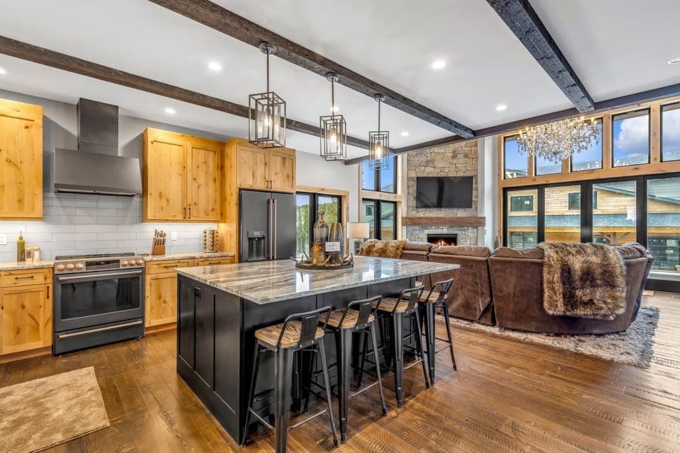 Open concept kitchen, living area, and dining area with fully stocked kitchen, state of the art appliances, breakfast bar seating for 6, and alpine views.