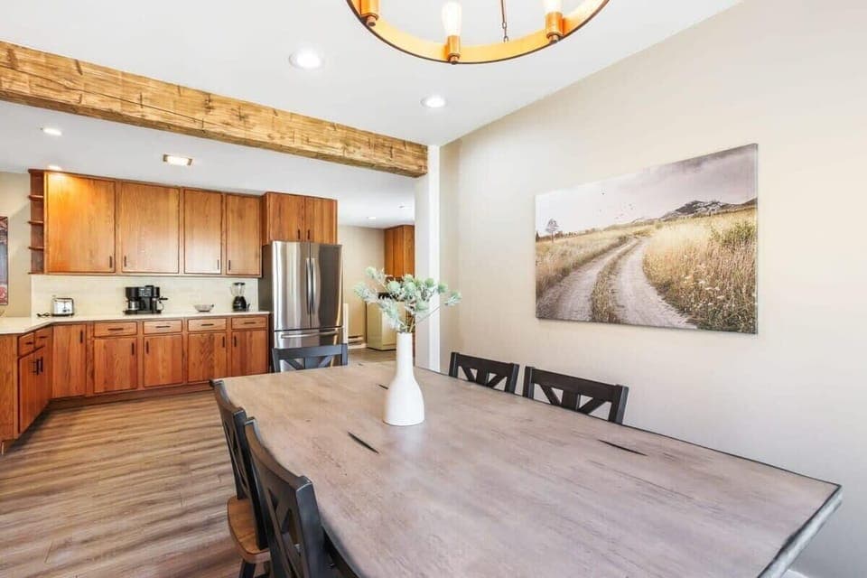 The dining room features stylish lighting, a wood-paneled accent wall and a large bay window to let in natural light while you dine. With seats for eight, it is conveniently situated just off of the kitchen for easy serving.