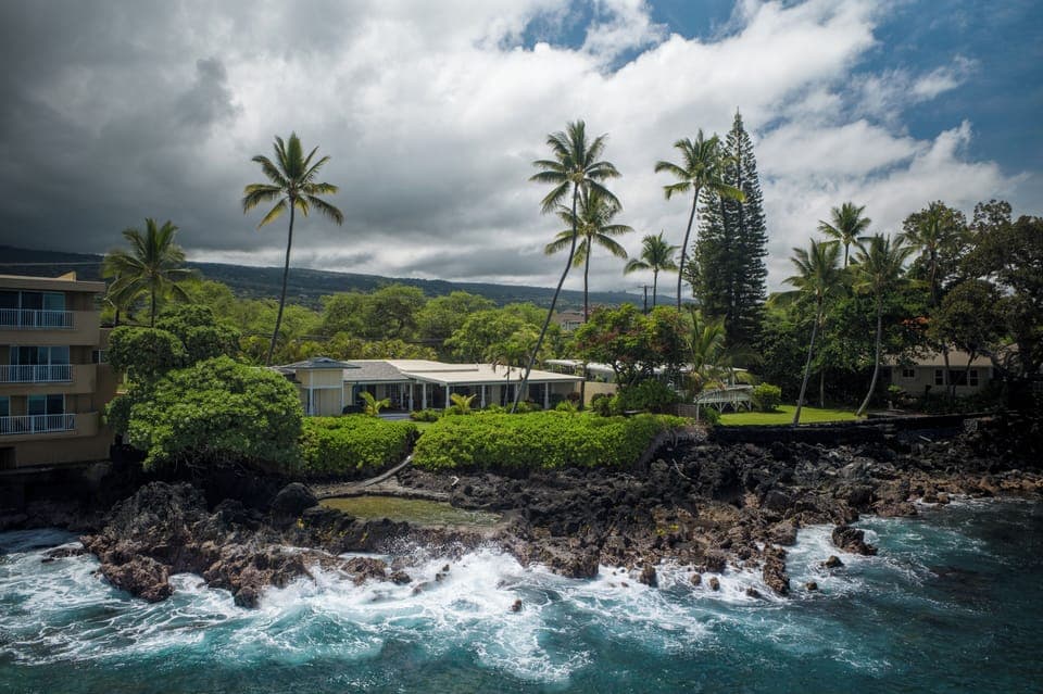 Stunning oceanfront property with dramatic waves and lush tropical landscaping
