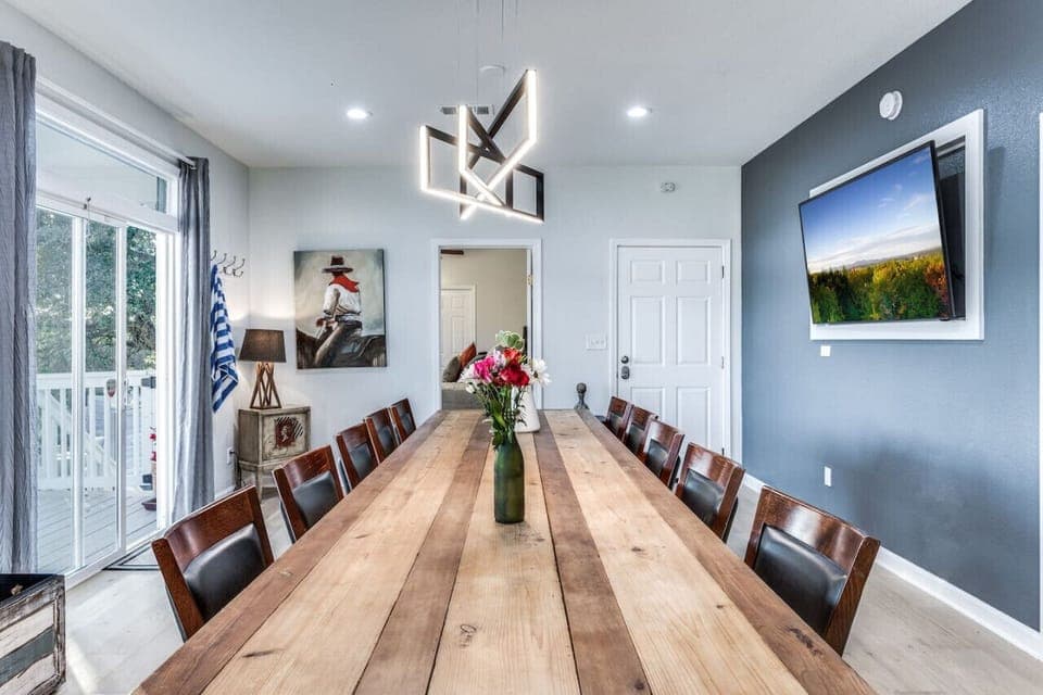 Dining table seats 10 and a giant tv monitor in the dining room with access to the large balcony