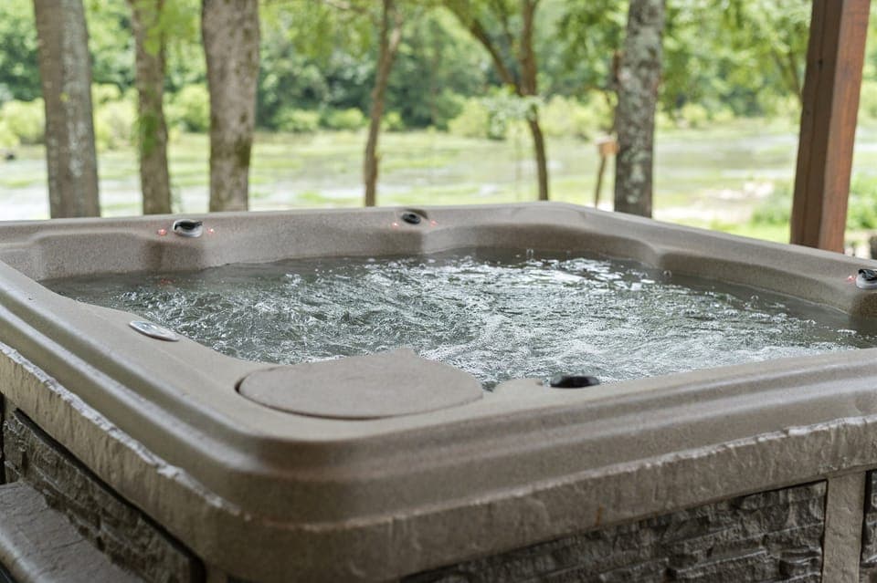 Relax in the private hot tub surrounded by peaceful nature