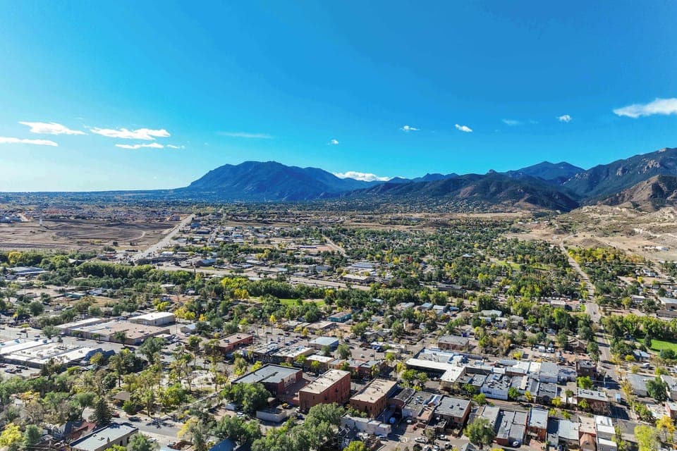 Stunning aerial view of Old Colorado City with the Rocky Mountains in the background, offering easy access to both urban attractions and outdoor adventures.