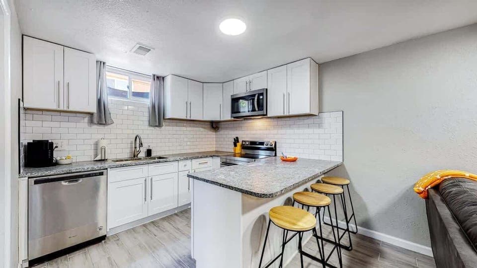 The kitchen features charming barstool seating, adding a touch of style and comfort for casual dining or enjoying a drink. It’s the perfect spot to gather and relax.