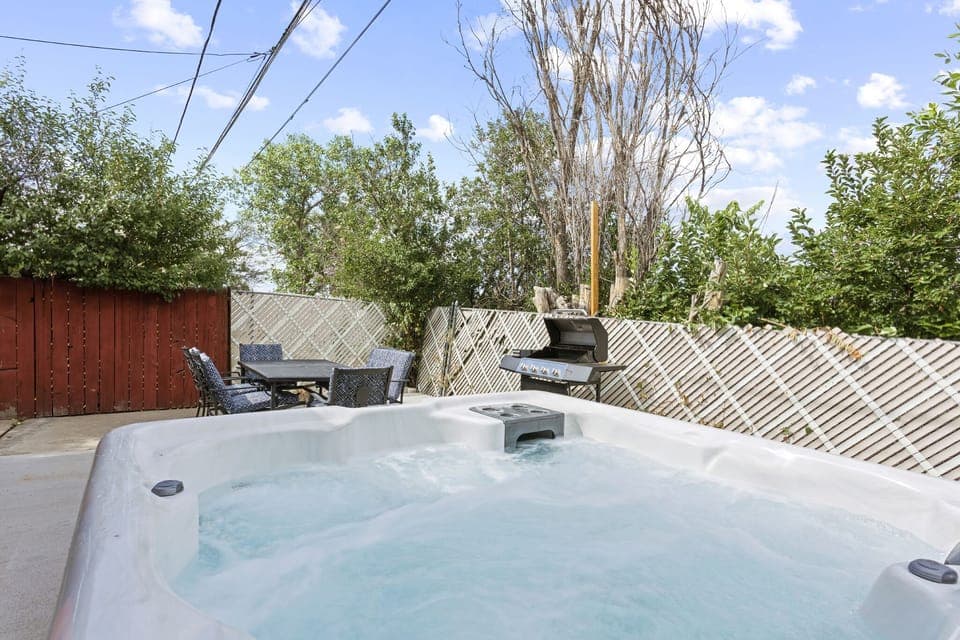 Backyard Bliss Unveiled!  - Step into relaxation and culinary delights with a hot tub and grill area in your backyard.