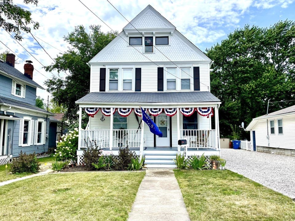 1920s, Victorian style home featuring a big front porch & patriotic bunting. 